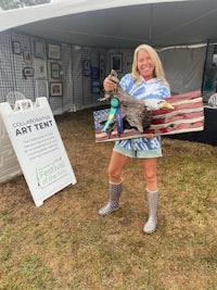 a woman holding a flag in front of a tent